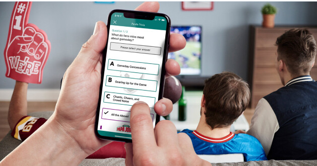 InsightsYOYgraph-1-4-e1693579617898 Person holding a cellphone, in front of a tv with sports on.